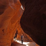 A hiker under a shaft of light, in Buckskin Gulch, in Vermillion Cliffs National Monument, Utah. Accessed from Wire Pass Hiking Trail. Easy Hikes. Grand Canyon Area