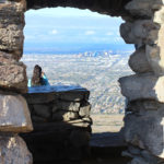 A hiker looking over downtown Phoenix, from Dobbins Lookout, at the top of the Holbert Hiking Trail, in South Mountain Park, Phoenix, Arizona. Stone structure, View, Moderate Hiking Trails, Phoenix Area Hiking Trails. copyright azutopia.com. No use without permission.