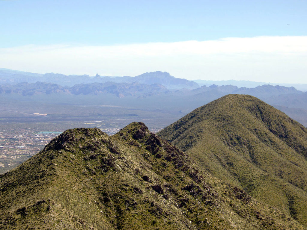 High view over top of McDowell Mountains; from Thompson Peak; Weavers Needl; Flatiron; Fountain Hills in the distance. Phoenix Area Hikes; Difficult Hikes; Fountain Hill; Arizona. Copyright azutopia.com. No use without permission.