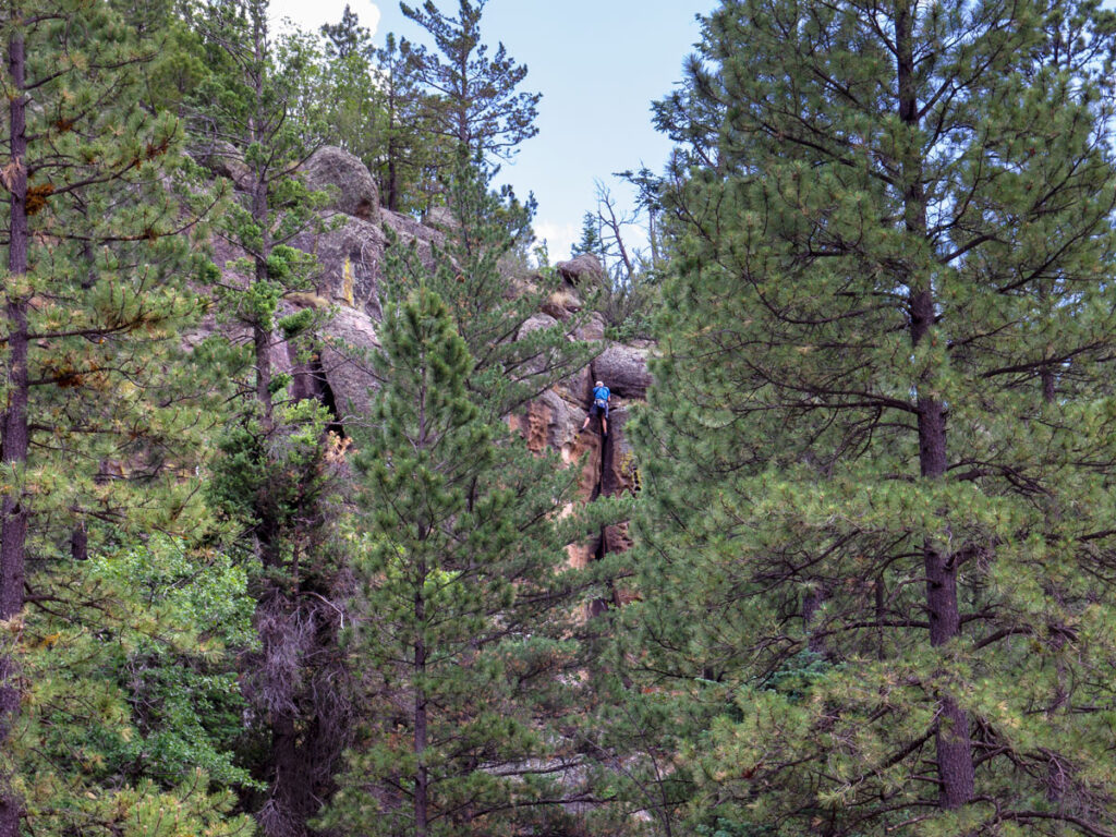 Landscape, Rock Wall and Pine Trees, Rock Climber belaying down wall, along Brookbank Hiking Trail, Sky and Clouds, Flagstaff, Arizona, Moderate Hiking Trails, Dog Friendly Hiking Trails, Copyright azutopia.com, No use without permission.