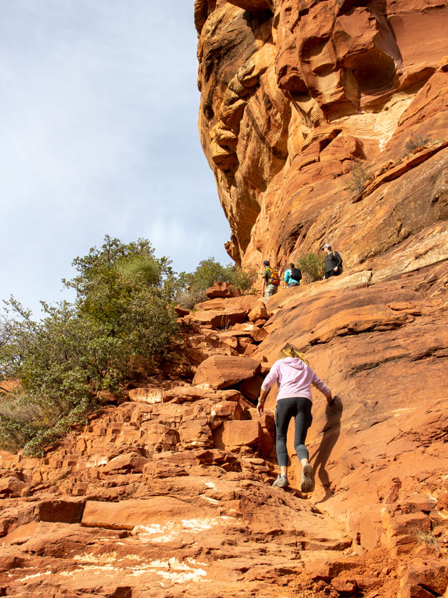 Landscape view of hikers ascending a steep area near the back end of Fay Canyon in Sedona, Arizona’s, red rock formations and cliffs, Fay Canyon Hiking Trail, Easy Hiking Trails; Northern Arizona Hiking Trails, Family Friendly Hiking Trails, Copyright azutopia.com. No use without permission.